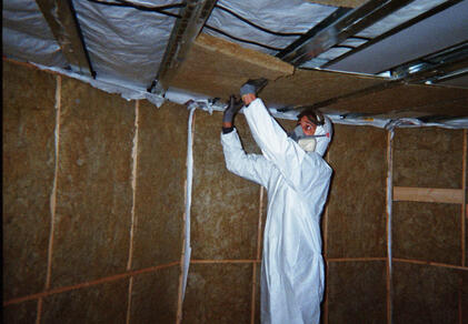 Inserting rockwool in the metal ceiling frames.